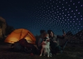 Amazon Leo direct-to-device satellite service illustration with a smartphone outdoors