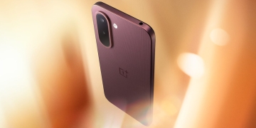 OnePlus N6x in Burgundy Red held at an angle, showing the textured rear panel and capsule camera island