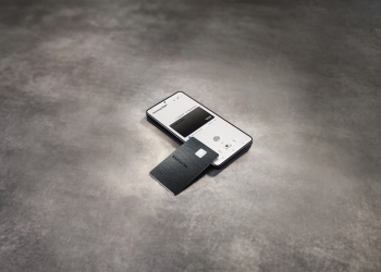 Samsung Galaxy Card in black metal resting on a Galaxy phone showing the card in Samsung Wallet