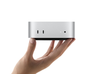 Apple Mac mini M6 held in a hand, showing its compact aluminum body