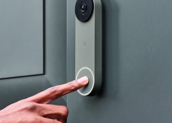 Nest Doorbell mounted on a wall with a hand pressing the button, the device affected by the Gemini US accent bug