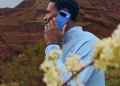 Person holding a blue Google Pixel phone to their ear during a phone call, outdoors