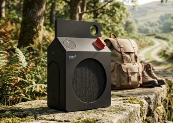 CMF Speaker S in matte black with carry handle and orange volume knob, staged outdoors
