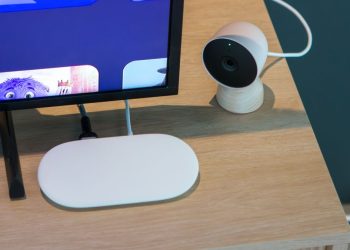 The current Google TV Streamer puck on a wooden table next to a TV, ahead of a next-gen Google TV Streamer leak
