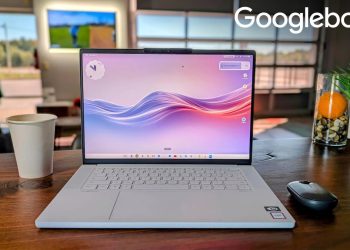 Lenovo Googlebook laptop open on a wooden table showing its Android home screen with widgets