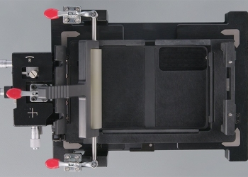 iPhone Duo held open in Apple's inner display fixture with roller bar, red clamps and micrometer knobs