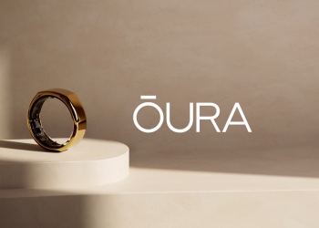 Gold Oura smart ring on a beige pedestal beside the Oura wordmark, illustrating Oura's lawsuit against Ultrahuman
