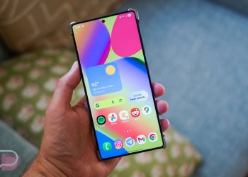 Galaxy S25 held in hand showing the One UI home screen