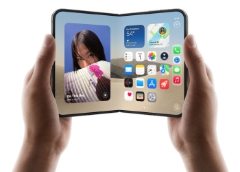 Apple iPhone Duo held open in two hands showing the iOS home screen, sold by Verizon